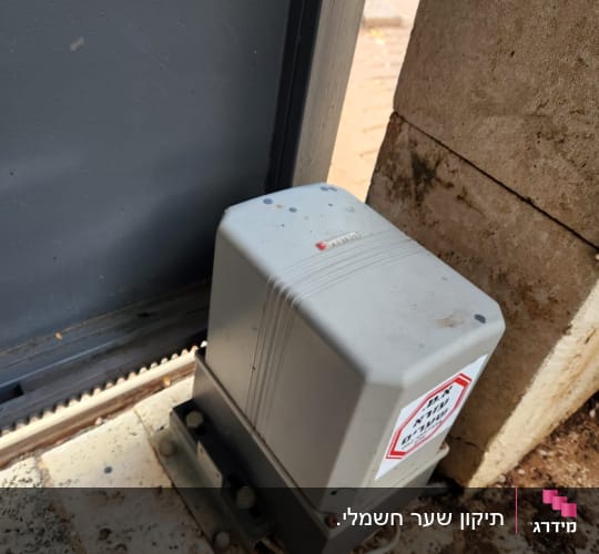 מנוע חשמלי לשער מתכת על רצפה מרוצפת